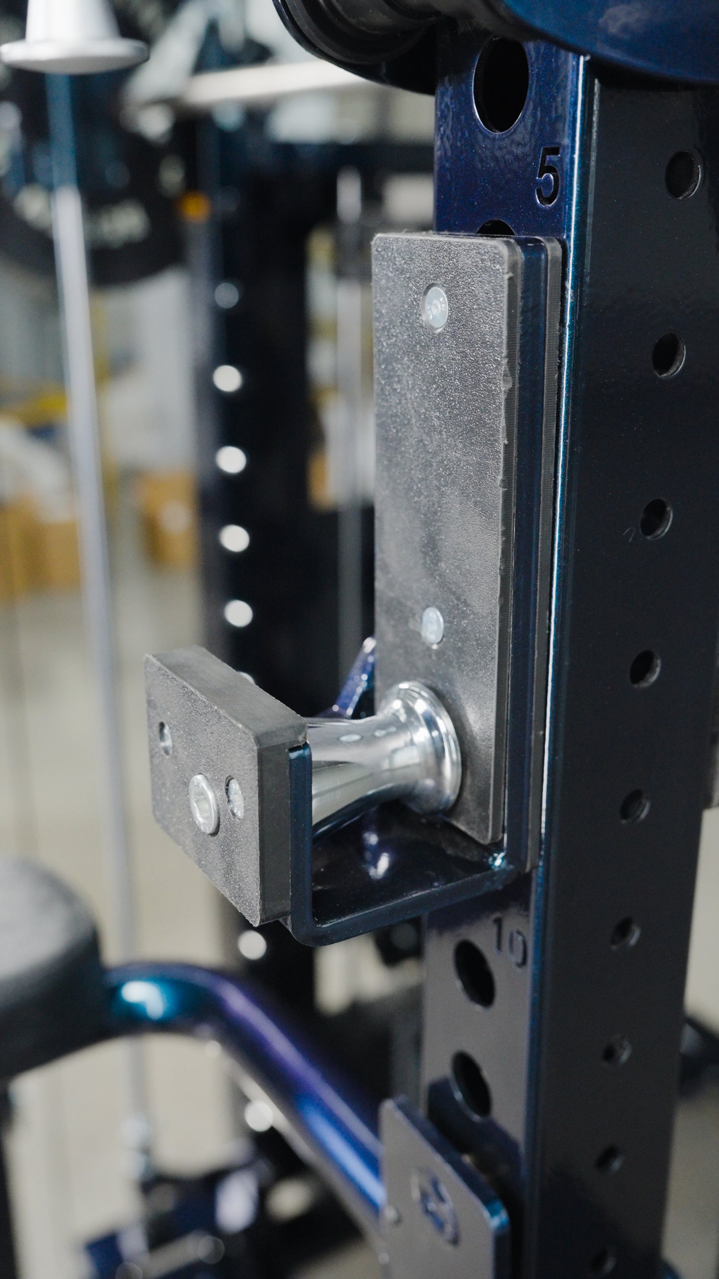 Close-up of a metal adjustment pin in the numbered holes of The Professor all-in-one trainer power rack by BefitNow Canada, used to set attachment height for home gym equipment.
