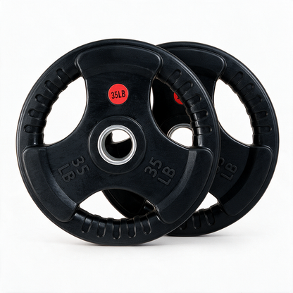 Two black 35-pound Premium Rubber Plates from BefitNow Canada, each featuring three grip holes, are stacked with a slight overlap on a white background. Crafted from ultra-durable virgin rubber for low bounce and sold in pairs with a lifetime warranty, one plate is marked with a red 35LB sticker.