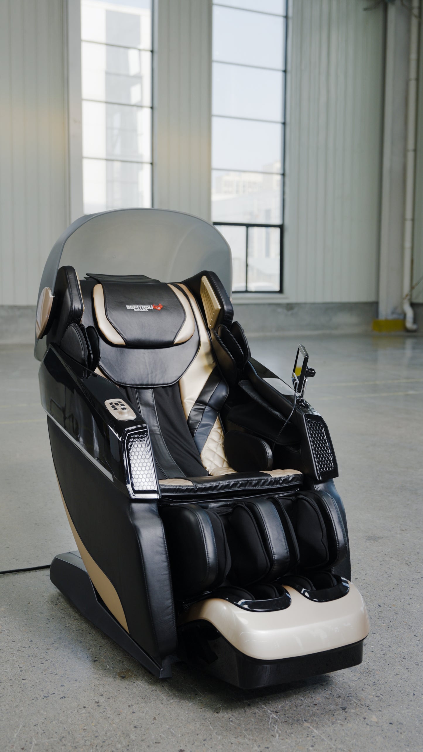 The BefitNow Canada 4D SL Luxury Voice Control Custom Massage Chair, featuring a built-in touchscreen panel, stands in a spacious industrial-style room with large windows and concrete floors.
