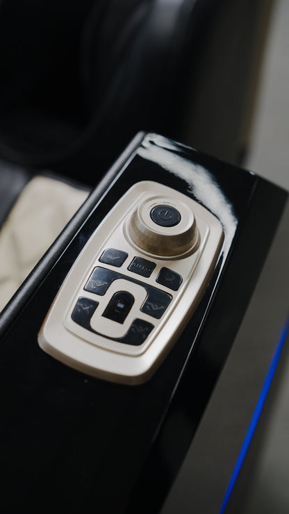 Close-up of the BefitNow Canada 4D SL Luxury Voice Control Custom Massage Chair's control panel, featuring black buttons and a round dial on a sleek black surface.
