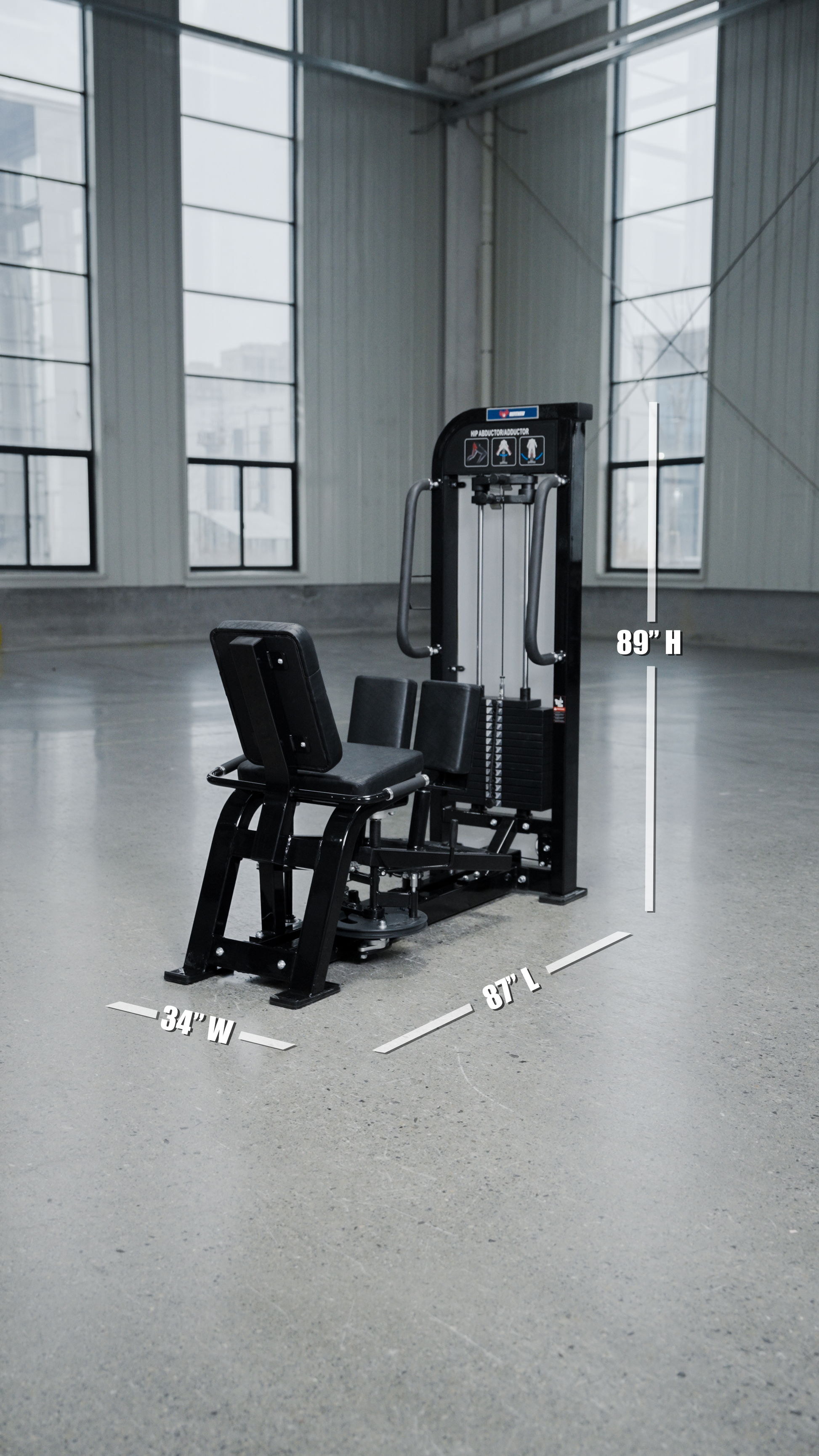The BefitNow Canada HS32 Abductor/Adductor gym machine, in black with a weight stack, sits in a spacious room with large windows. White text displays its dimensions: 34" wide, 87" long, and 89" high.
