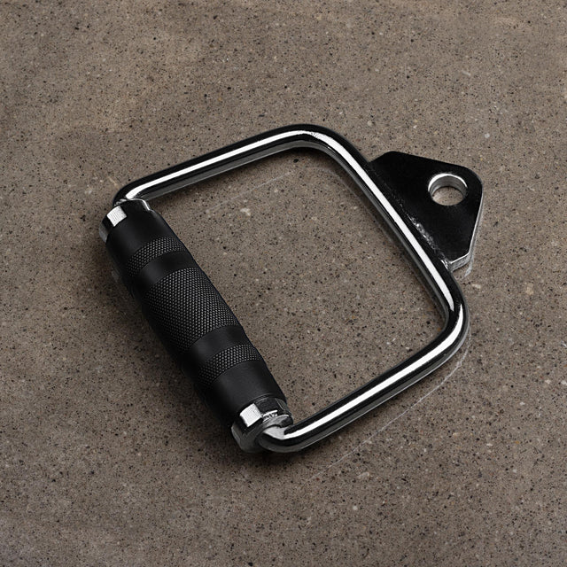 A BefitNow Canada Steel D Handles Pair, featuring a black and silver design with rubberized grips, sits on a gray concrete surface. These handles include metal rings for easy attachment to gym equipment, ideal for enhancing your cable machine workouts.