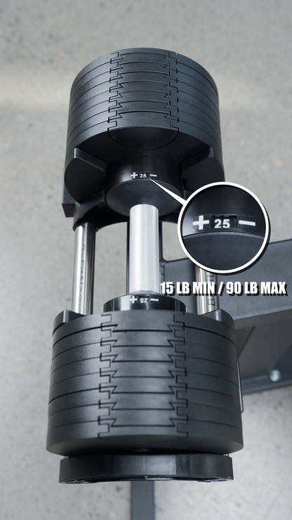 Close-up of the BefitNow Canada 90lbs Adjustable Cast Iron Dumbbell Pair—perfect for home gyms—with a dial set to 25 lbs and text “15 LB MIN / 90 LB MAX.” The black dumbbell with silver handle rests on a gray surface.
