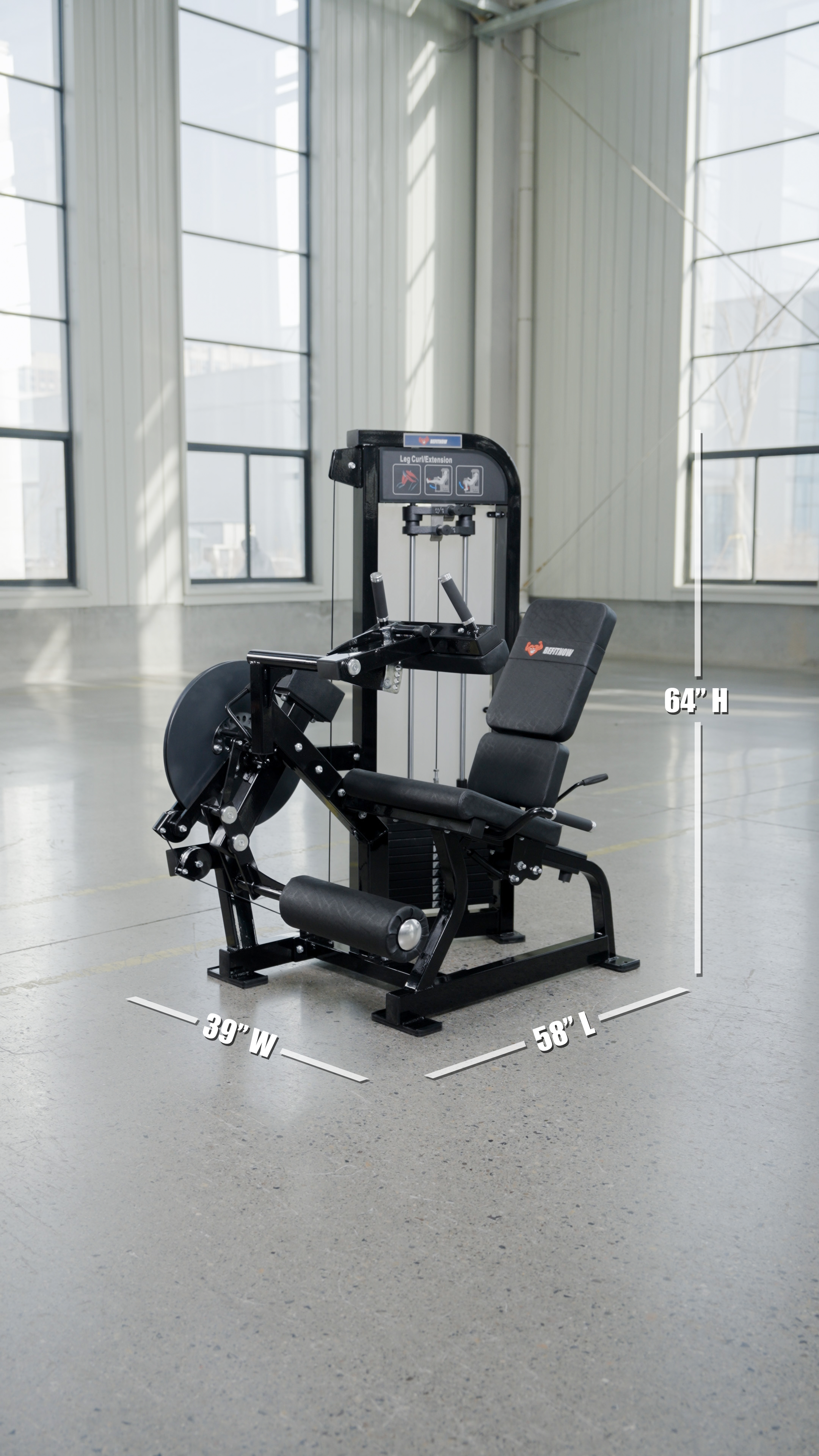 The BefitNow Canada Dual Function Leg Extension Leg Curl Machine, black and heavy-duty with adjustable seat and weights (64"H x 39"W x 58"L), sits in a spacious, well-lit gym with large windows. Perfect for leg extension and strength workouts.