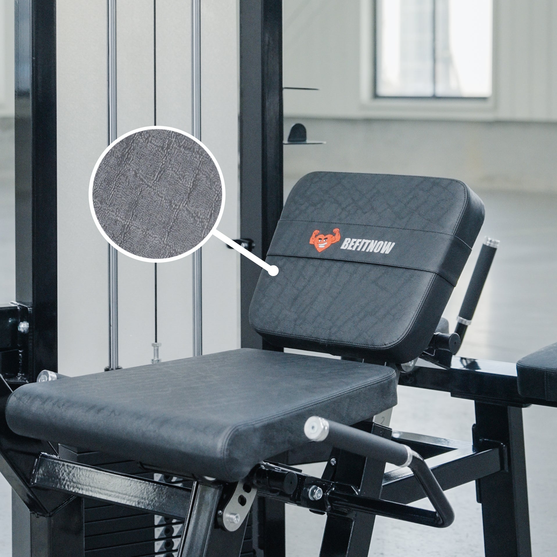 A Leg Extension/Lying Down Leg Curl machine by BefitNow Canada features a black padded seat with the BefitNow logo. An inset circle shows a close-up of the textured upholstery, and the equipment is placed in a gym setting.