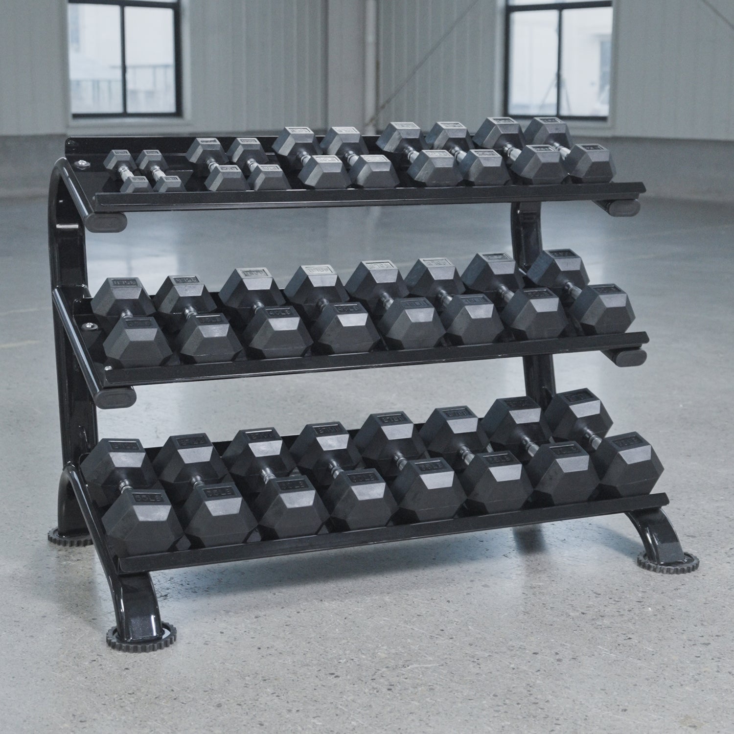 The BefitNow Canada 3 Tier Commercial Hex Dumbbell Rack displays black hex dumbbells on a smooth concrete floor in a spacious, well-lit gym with large windows.