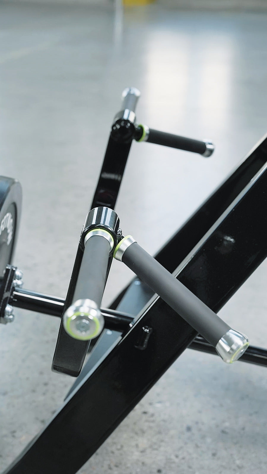 Close-up of the BefitNow Canada AR61 Incline Level Row’s black and silver handle with padded grips for upper and mid-back workouts, attached to metal bars over a smooth light gray gym floor—ideal for home gyms.