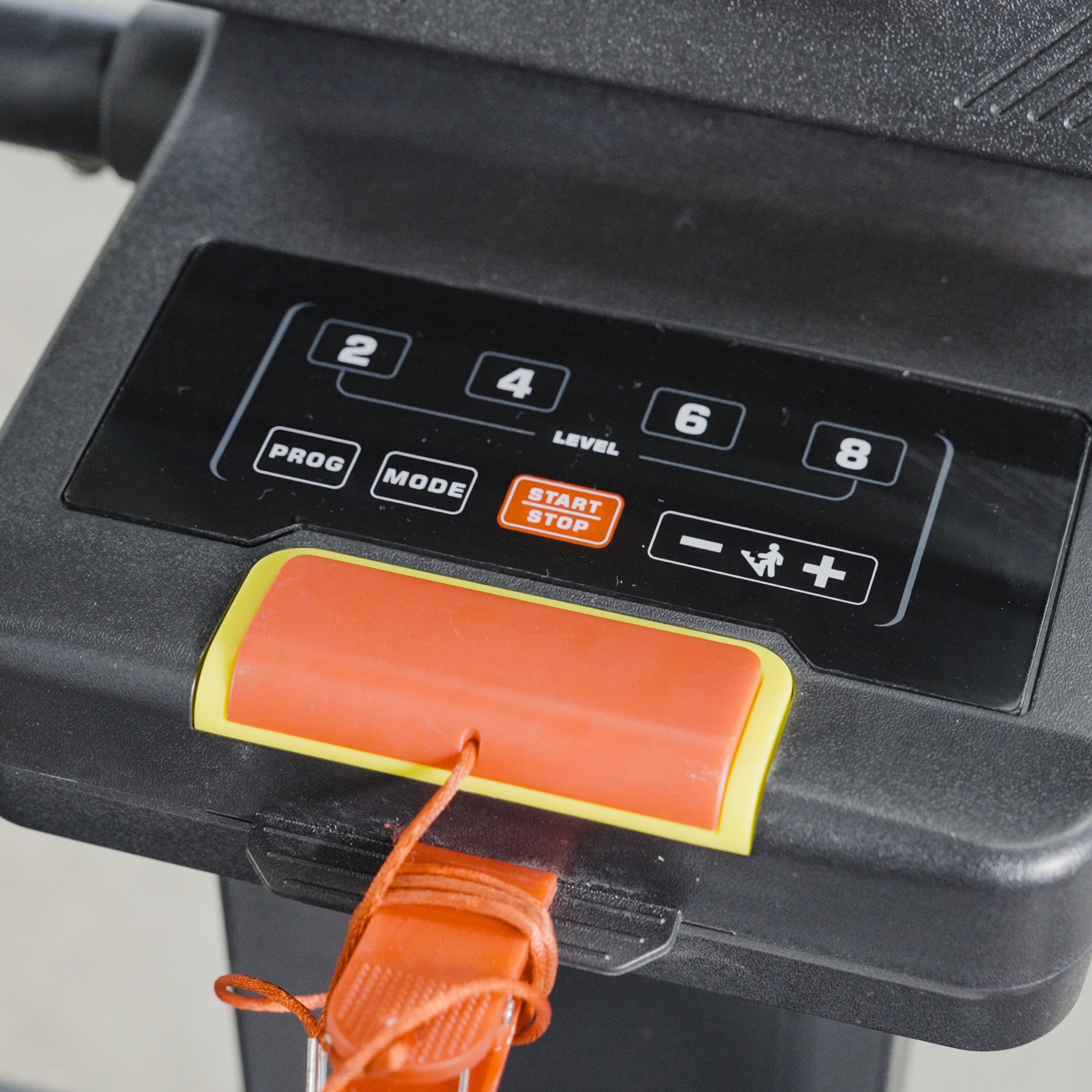 Close-up of The SkyStep Stair Climber control panel by BefitNow Canada, featuring buttons for levels, program, mode, start/stop, and speed adjustment. A safety key with red strap is attached below. Perfect for effective cardio training.