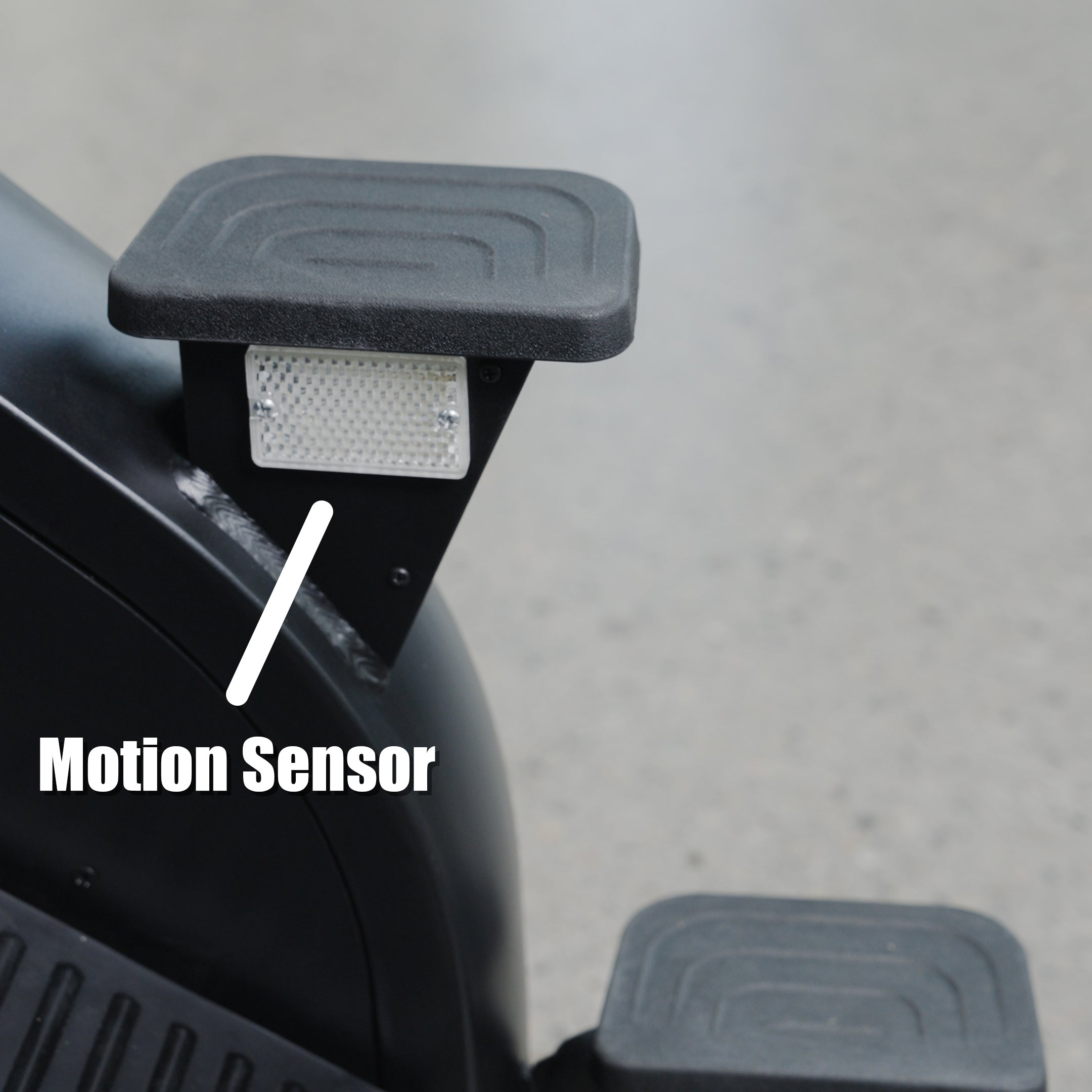 Close-up of The SkyStep Stair Climber pedal by BefitNow Canada, featuring a motion sensor marked by a white label and arrow. Set against a gray speckled floor—ideal for effective cardiovascular training.