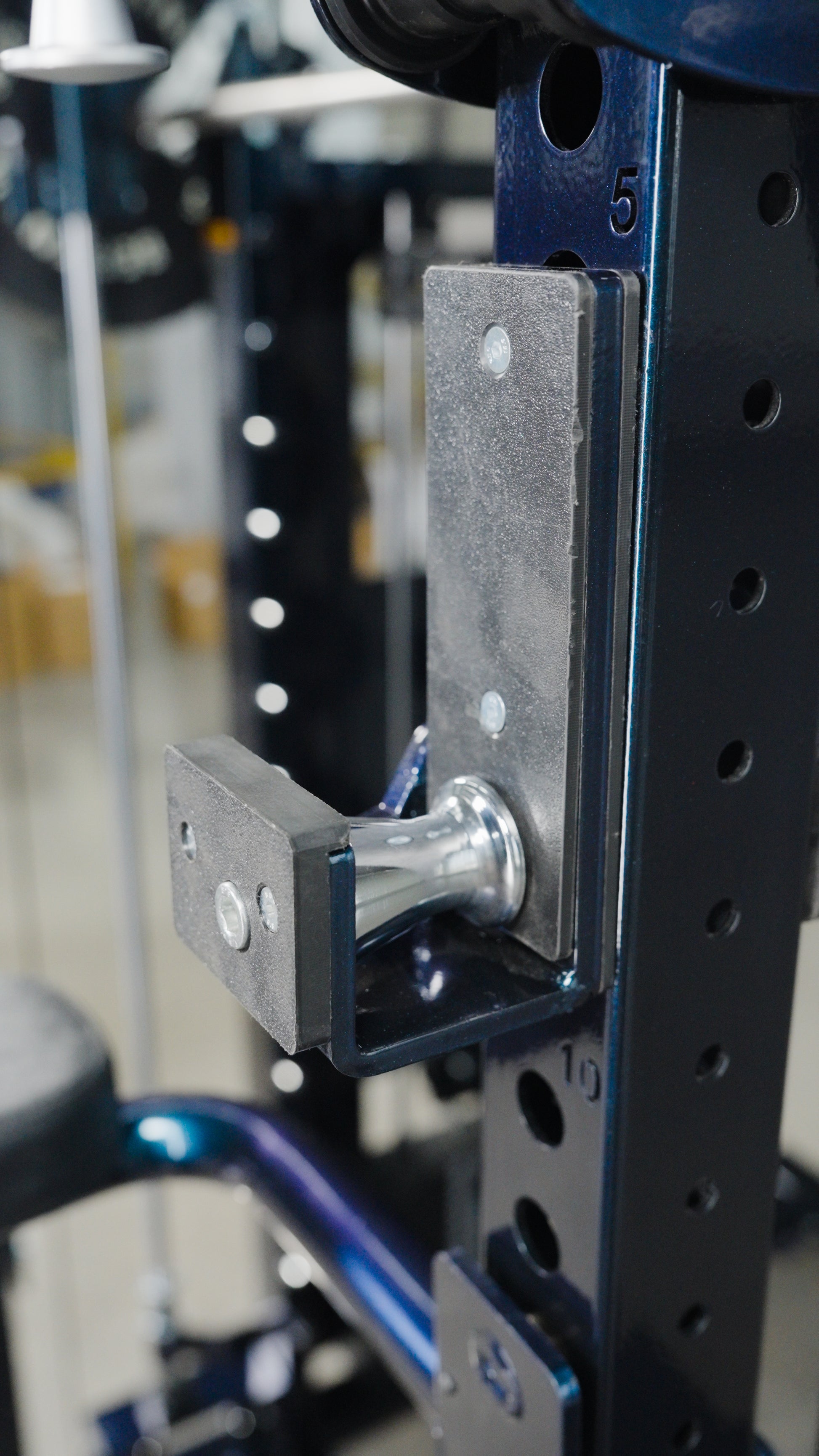 Close-up of a metal adjustment pin in the numbered holes of The Professor all-in-one trainer power rack by BefitNow Canada, used to set attachment height for home gym equipment.