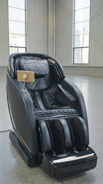 The BefitNow Canada SL Full Body Commercial Massage Chair, featuring quilted black upholstery and a touchpad control on the armrest, offers a relaxing full-body massage in spacious rooms with large windows and concrete floors.