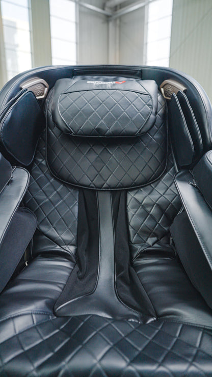 A close-up of the BefitNow Canada SL Full Body Commercial Massage Chair in black leather with quilted stitching and padded armrests, showcased in a modern, well-lit room.
