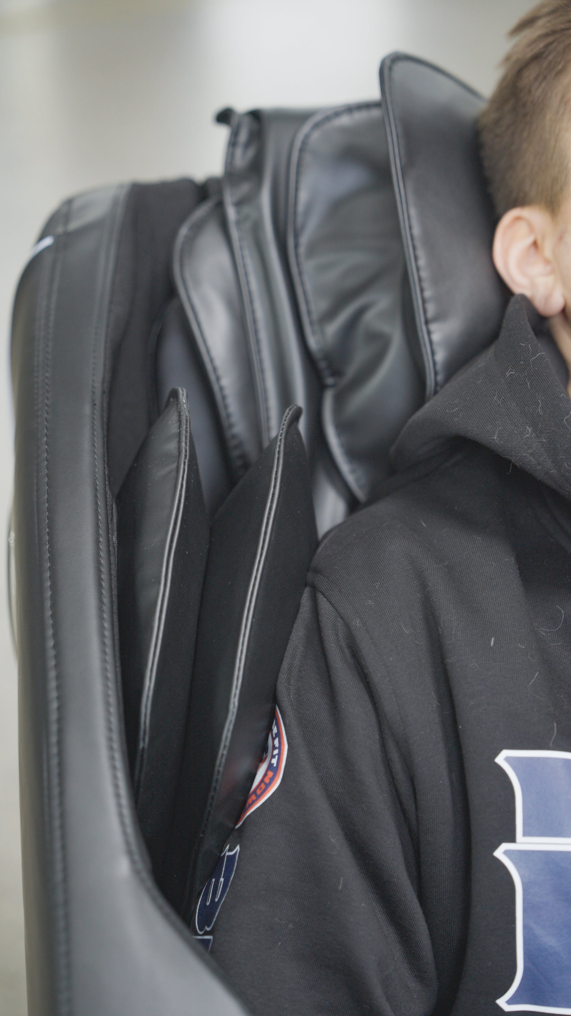 A person in a black hoodie relaxes in the BefitNow Canada Luxurious Zero Gravity Massage Chair. Only the right side of their upper body and head are visible, with their face partially out of frame.
