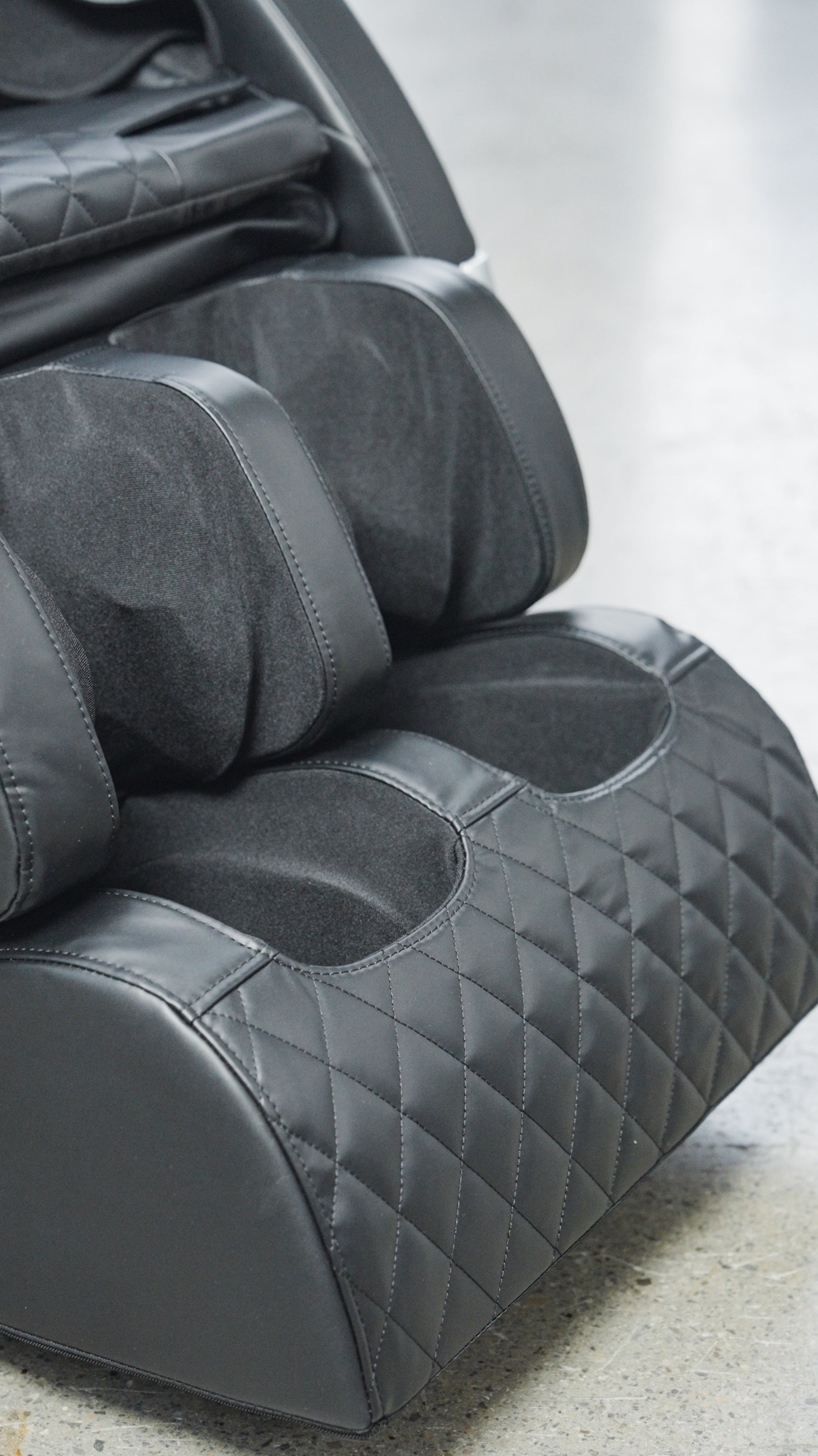 Close-up of the foot and calf section of the BefitNow Canada Luxurious Zero Gravity Massage Chair, featuring quilted and smooth padded surfaces for comfort and support, set on a gray concrete floor.