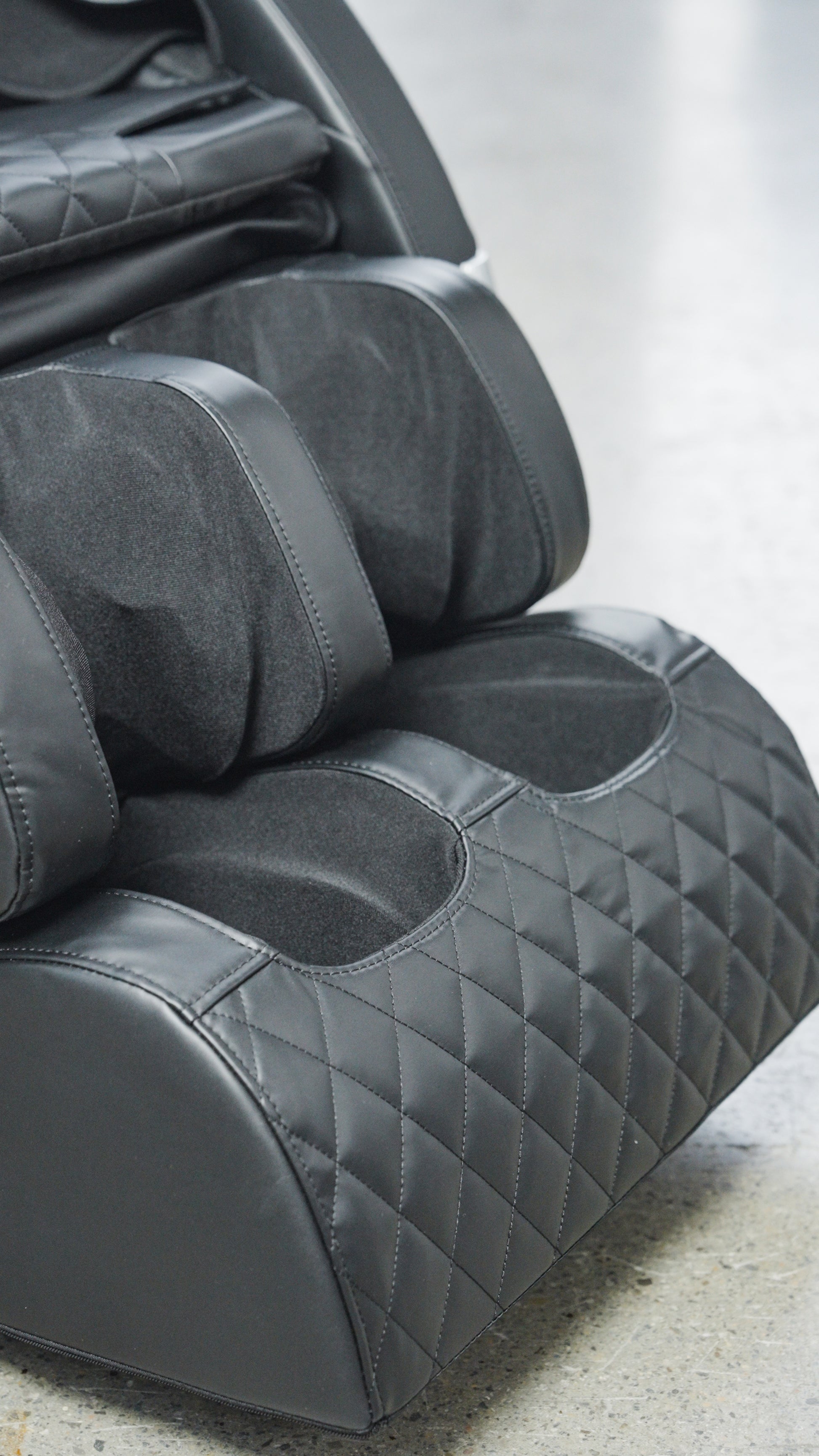 Close-up of the foot and calf section of the BefitNow Canada Luxurious Zero Gravity Massage Chair, featuring quilted and smooth padded surfaces for comfort and support, set on a gray concrete floor.