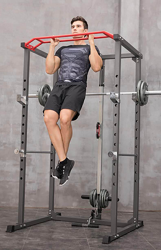 A man in athletic wear does a pull-up on the red Befitnow Canada Multi Functional Squat Rack with Lat Machine, set against a gray concrete wall in a gym.