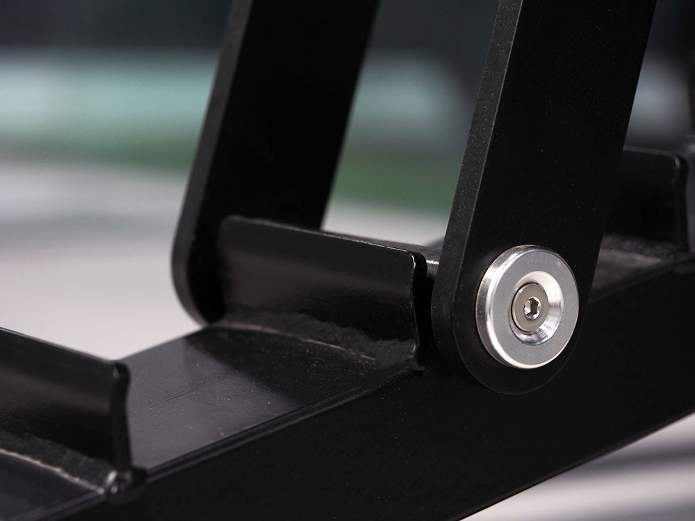 The sleek black metal hinge on the TM87 Fully Adjustable Commercial Bench by BefitNow Canada features a circular silver screw. Emphasizing its clean design and functionality, the blurred background highlights the benchs smooth finish and construction.