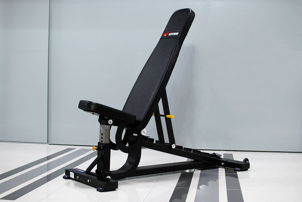 The TM87 Fully Adjustable Commercial Bench by BefitNow Canada features a custom-built design with a black padded seat and backrest, set against a gray backdrop. It boasts a sturdy metal frame and sits on an abstract patterned gray and white floor.