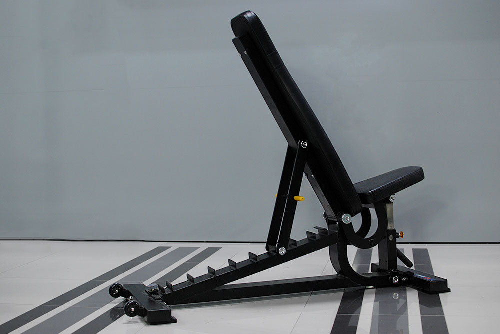 The TM87 Fully Adjustable Commercial Bench by BefitNow Canada is a custom-built black workout bench with a padded seat and backrest, set in an upright incline against a gray background. It features a sturdy metal frame with adjustable notches and wheels for easy mobility.