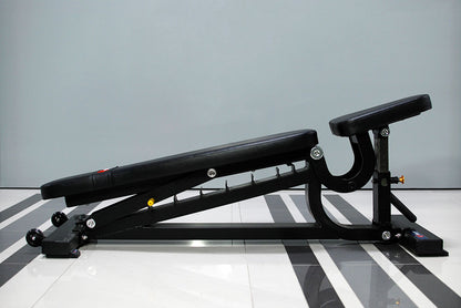 The TM87 Fully Adjustable Commercial Bench by BefitNow Canada, featuring black padding, is set in a decline position on a glossy, striped floor against a neutral wall.